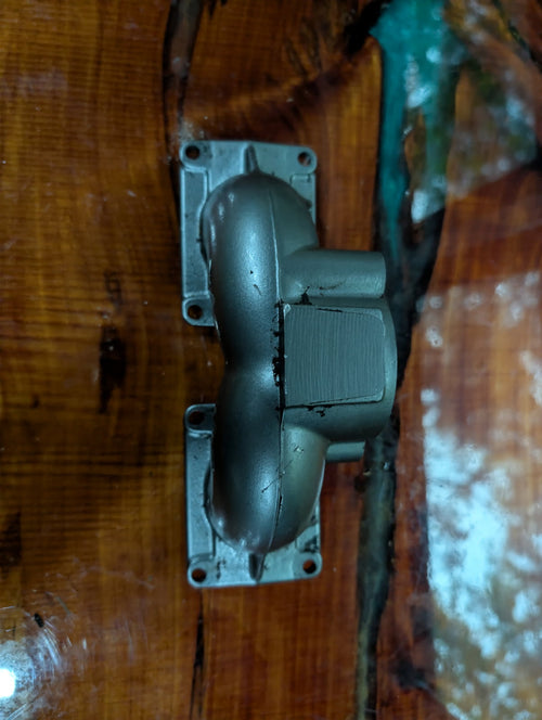 Kawasaki 650 intake manifold side view showing dual rectangular reed valve ports