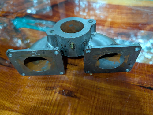 Kawasaki 650 intake manifold top view showing single round carburetor inlet and brass fitting